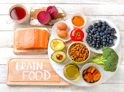 fish, fruits, and vegetables on a white background with the words brain food on a wooden board
